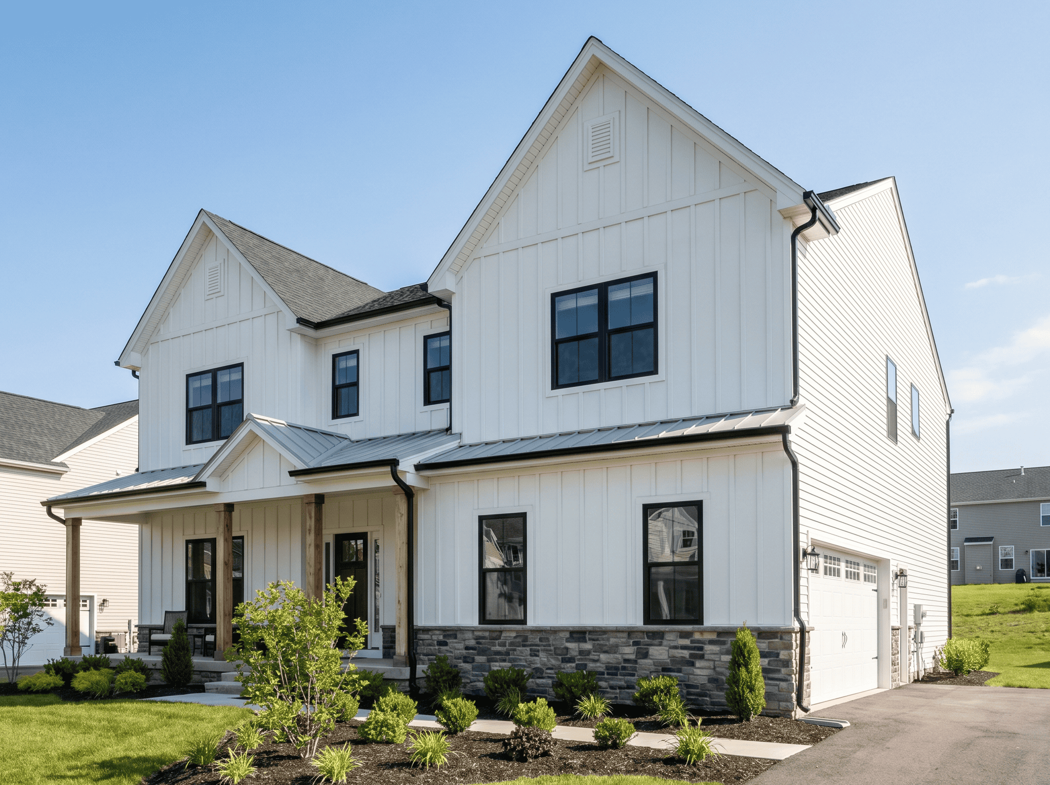 White house exterior renovation with siding and stone accents.
