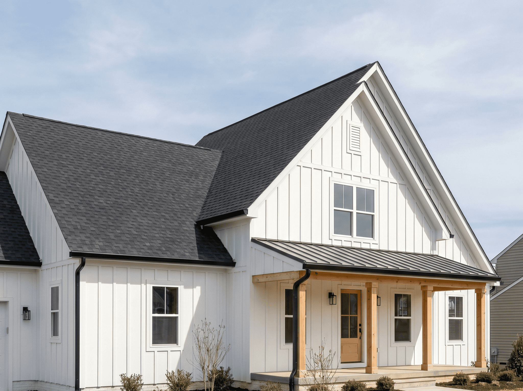 Beautiful modern farmhouse with white siding, black roof, and welcoming front porch.