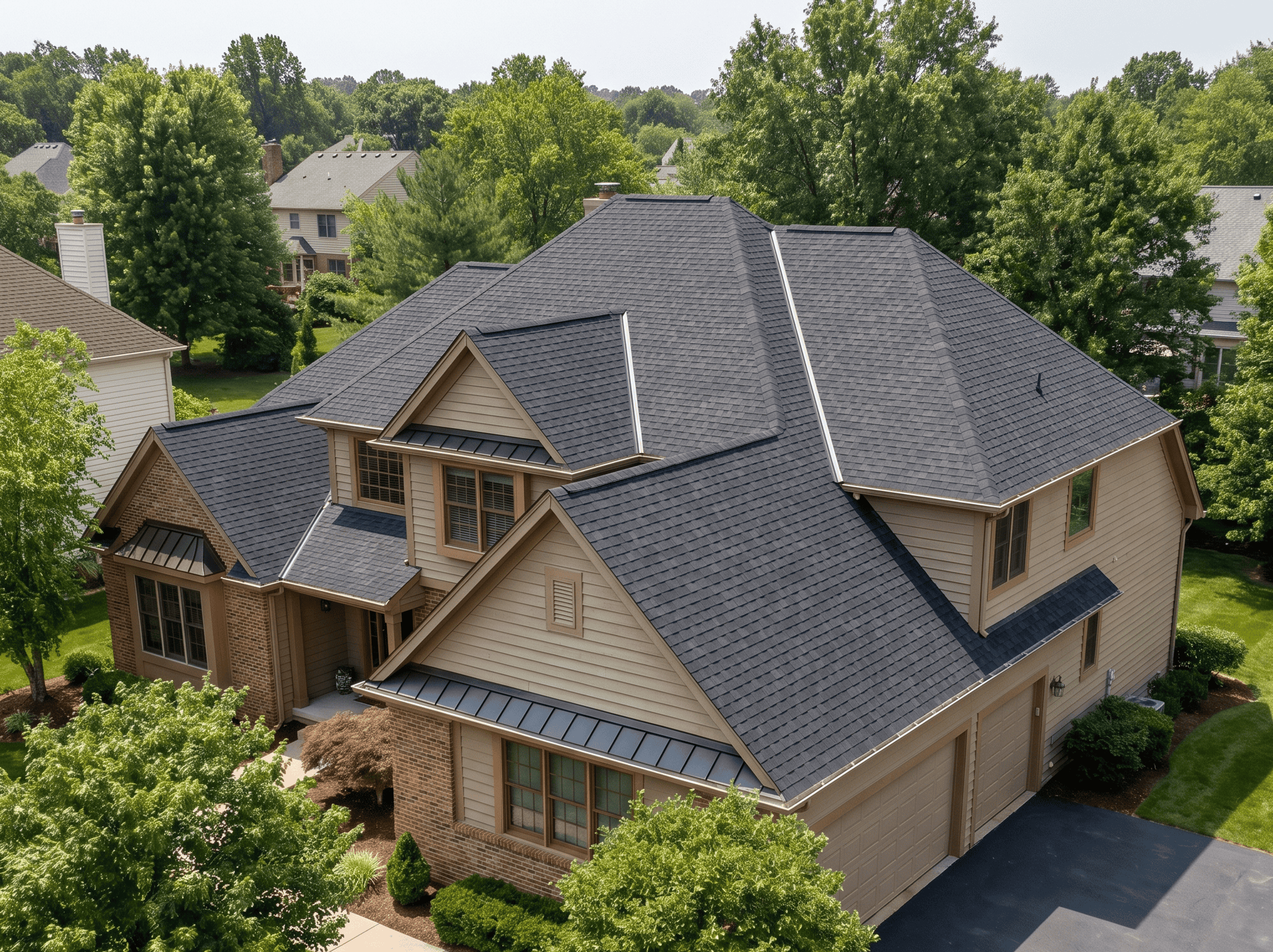 Beautiful modern house with a dark asphalt shingle roof and beige siding, surrounded by lush greener.