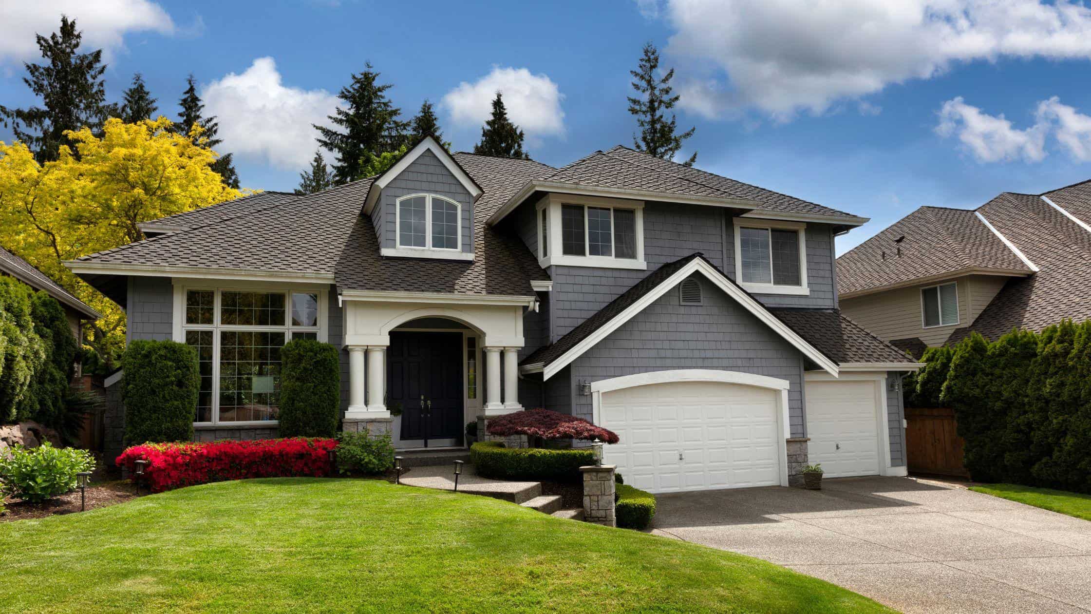 Beautifully renovated two-story house with a fresh gray exterior and landscaped yard. Perfect for ho.