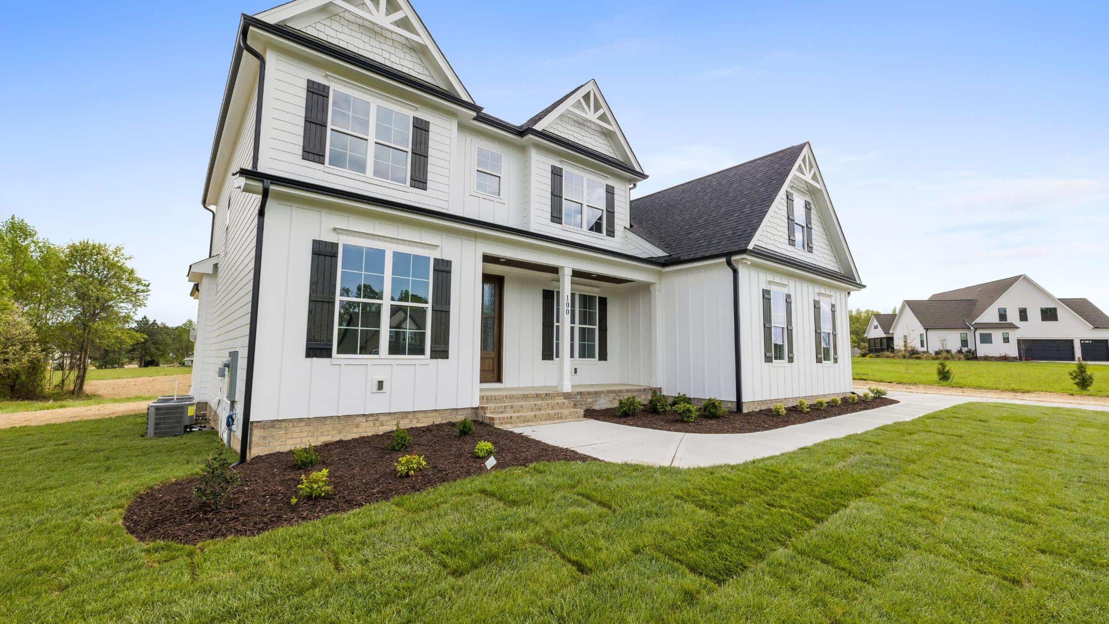 Modern White House Exterior Beautiful modern white house with large windows and landscaped yard, showcasing expert renovation an.
