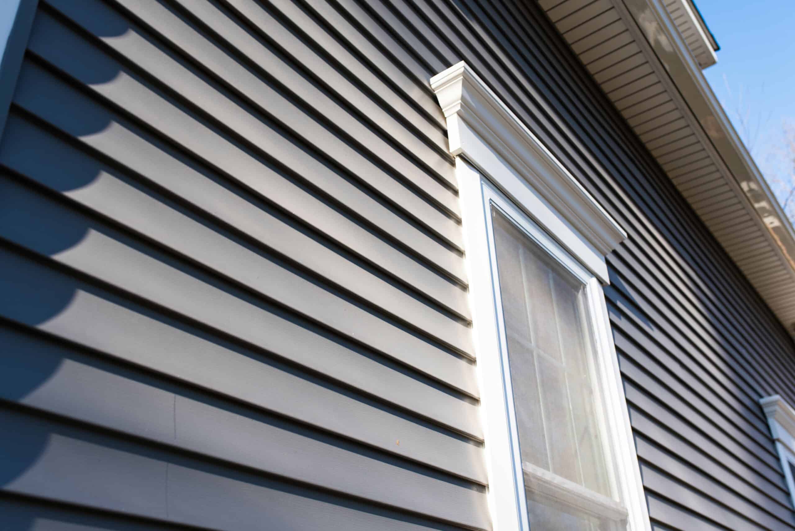 Siding Installation Close-up of modern vinyl siding on a residential house exterior.