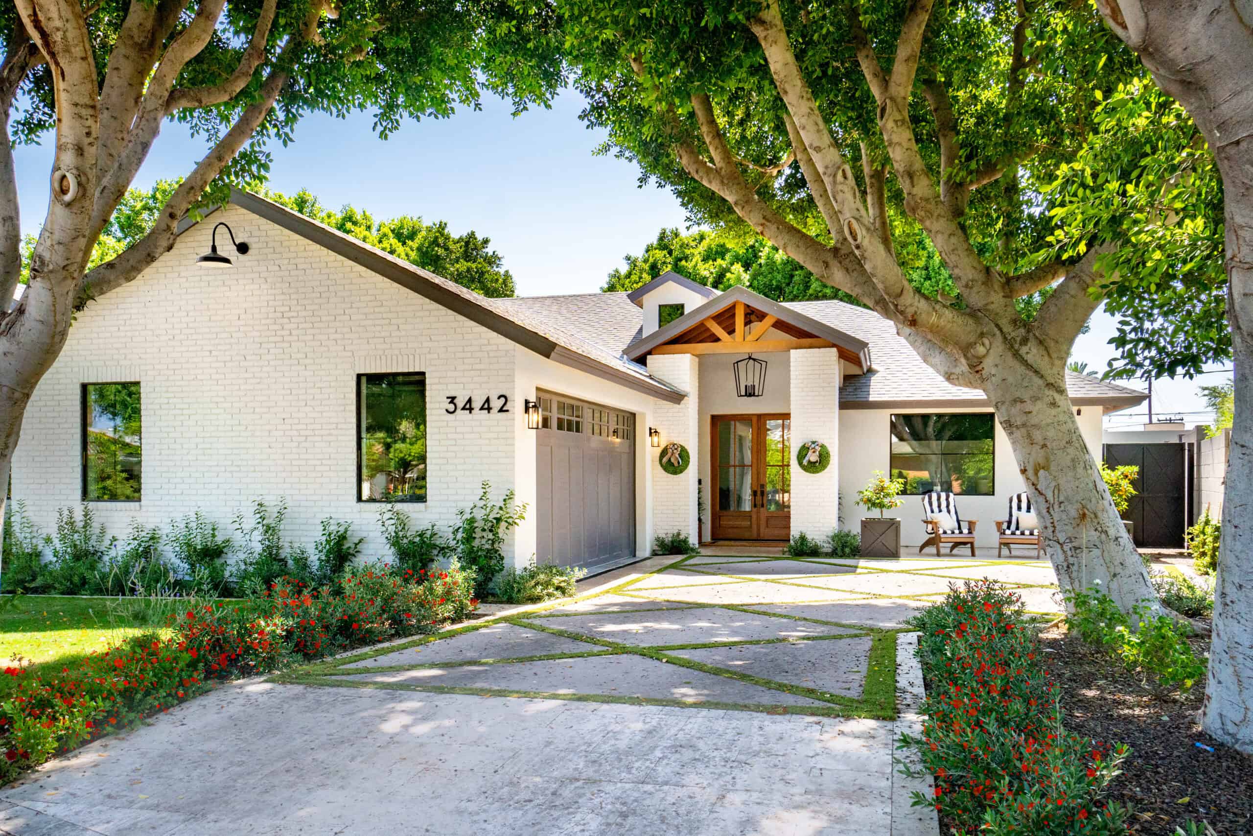 Modern Home Exterior Beautiful modern house with lush greenery and large trees in front.
