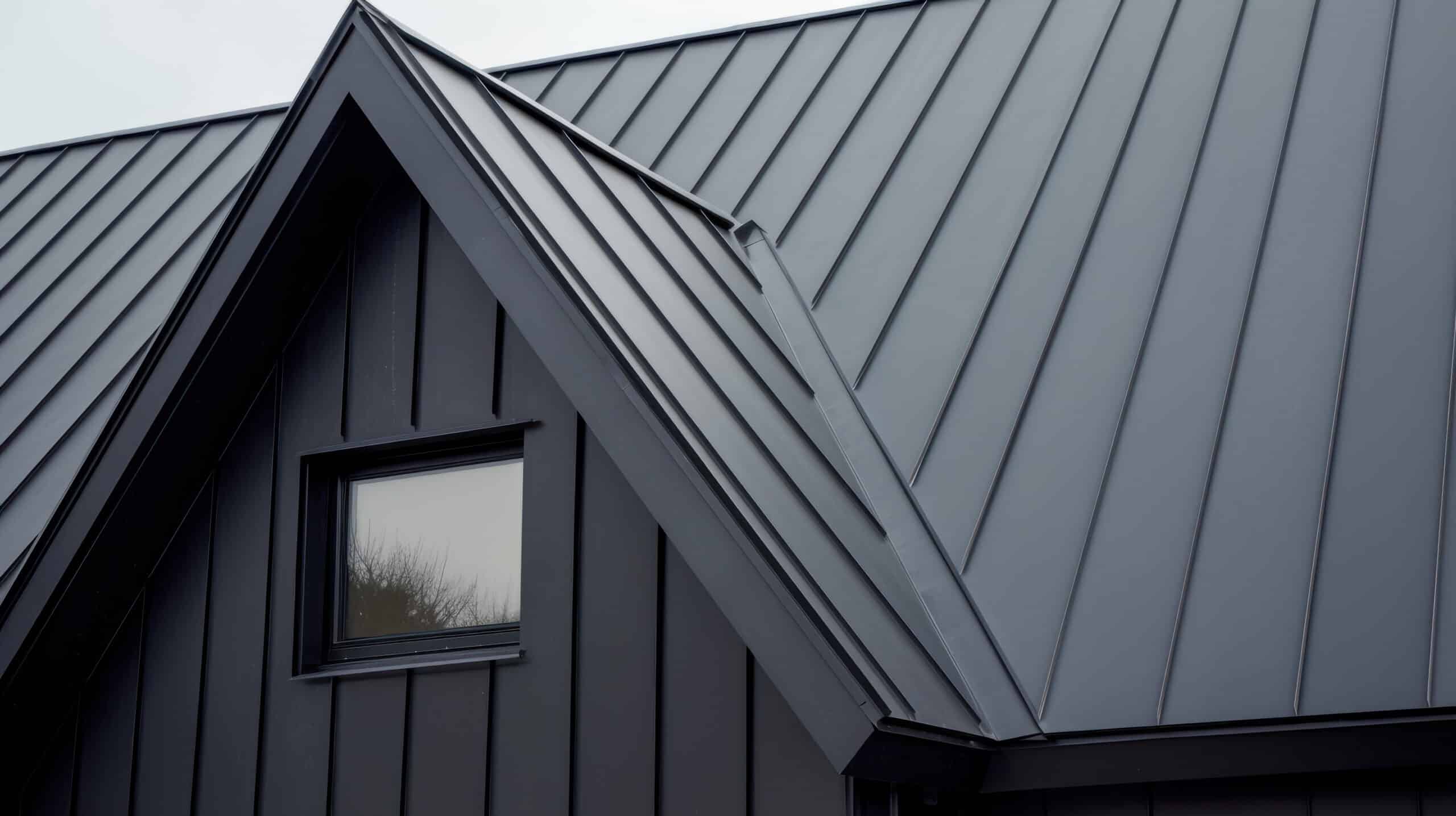 Close-up of a sleek, black metal roof with a dormer window.