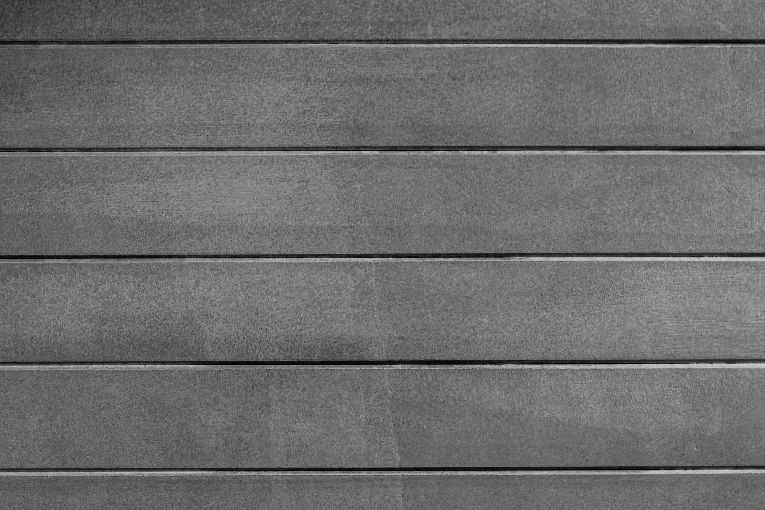Close-up of gray wall paneling showing horizontal wooden planks.