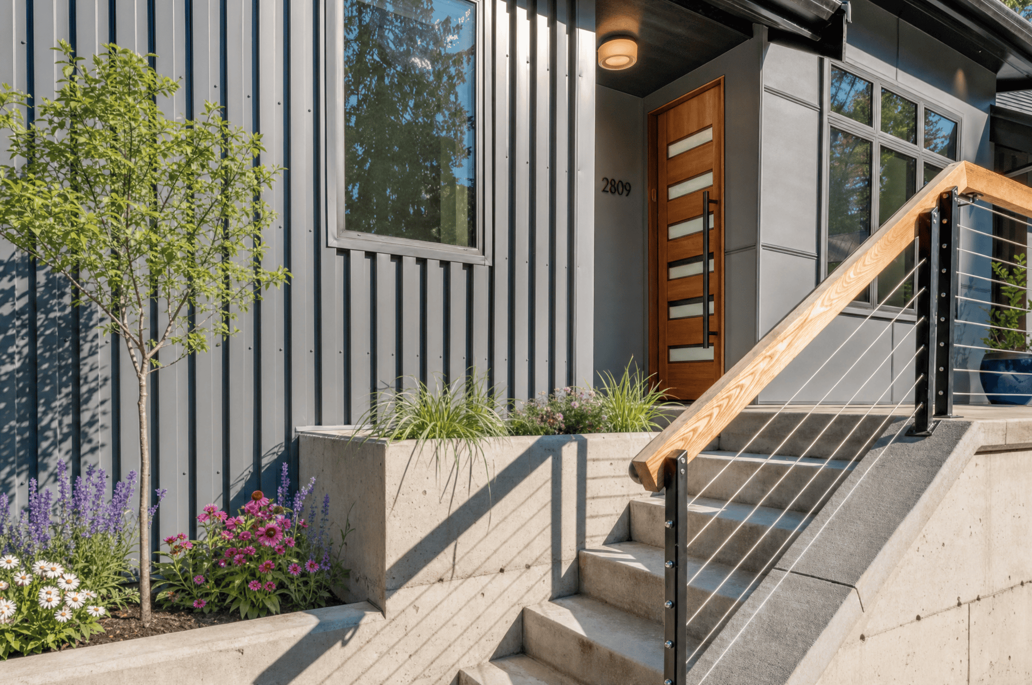 Contemporary house with metal siding, wooden door, and landscaped front yard.